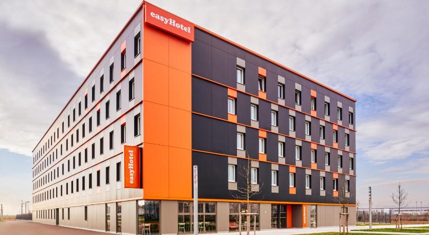 a large building with a clock on the front of it, easyHotel Paris Charles de Gaulle Villepinte in Paris