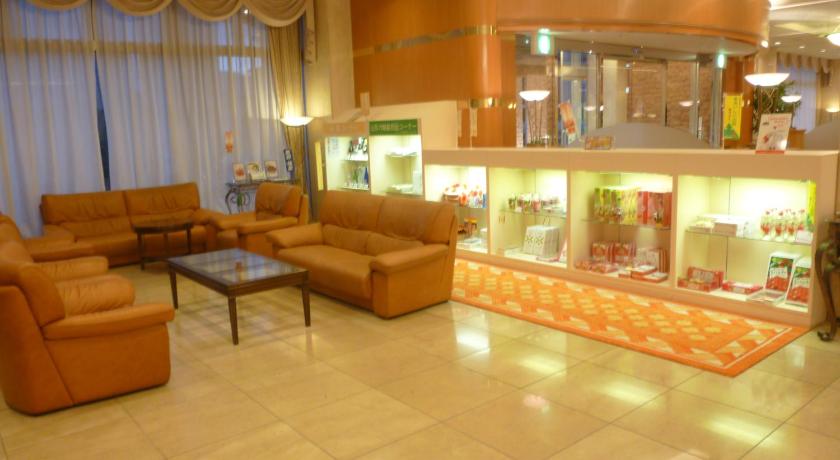 a living room filled with furniture and a large window, Yamagata Kokusai Hotel in Yamagata