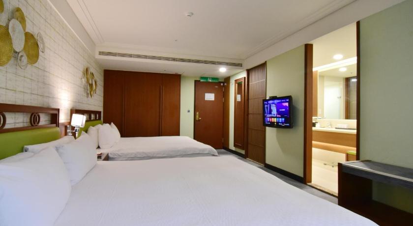 a hotel room with two beds and a television, Alishan Hotel in Chiayi