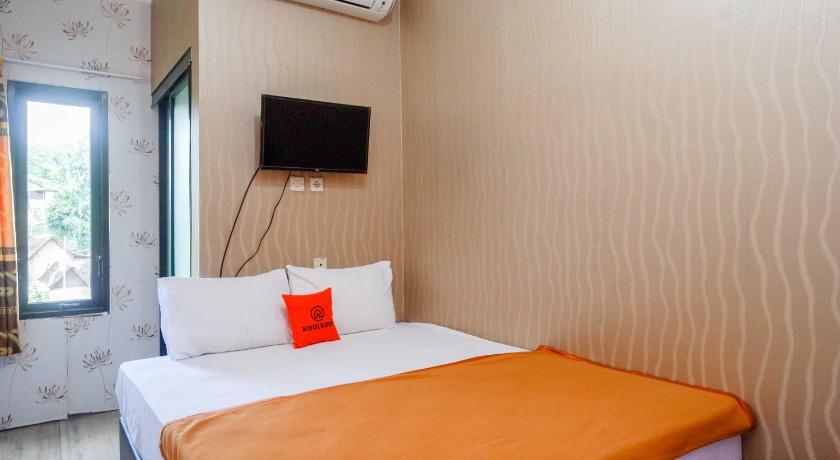 a hotel room with a bed and a television, KoolKost Syariah near Malioboro Area in Yogyakarta