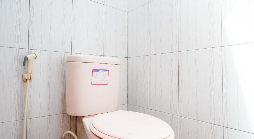 a white toilet sitting next to a white wall, KoolKost Syariah near Malioboro Area in Yogyakarta