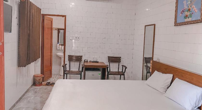 a hotel room with a bed, table and chairs, Khach san Ngoc Bich in Phan Rang – Tháp Chàm (Ninh Thuận)