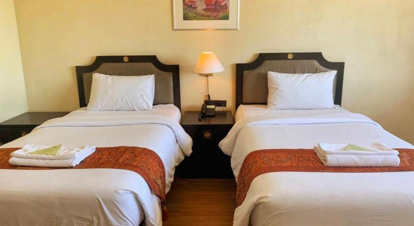 a hotel room with two beds and two nightstands, Wangchan Riverview Hotel in Phitsanulok