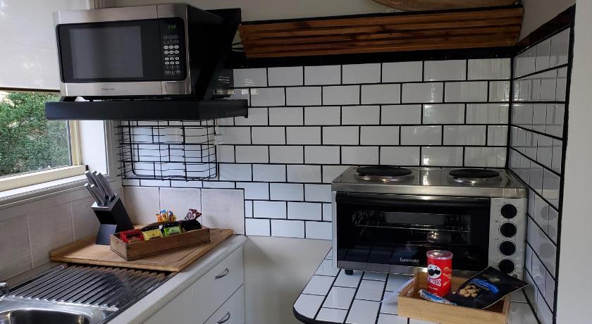 a kitchen with a stove, microwave, sink and dishwasher, Lakeside Studio in Jindabyne