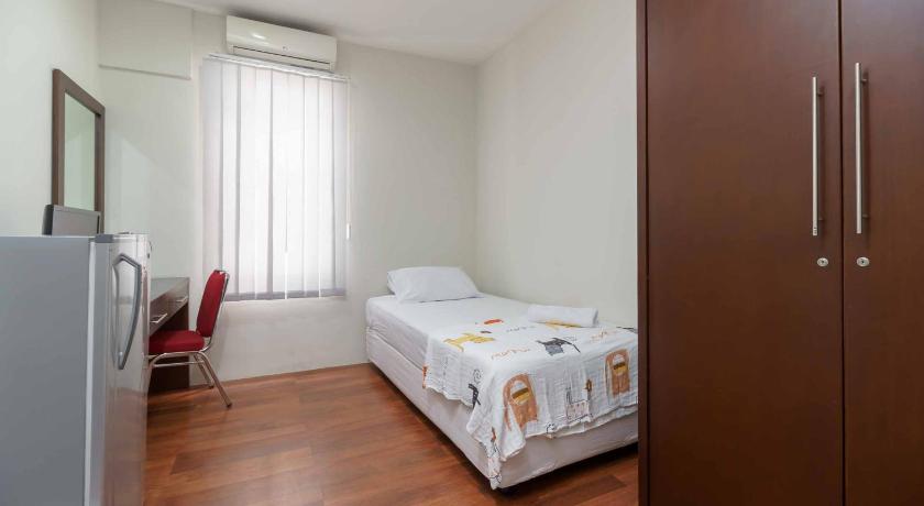 a bedroom with a bed and a dresser, Avalon Karawaci RedPartner in Tangerang