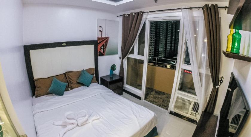 a bedroom with a bed and a mirror, BIRCH TOWER - MALATE ROOMS in Manila