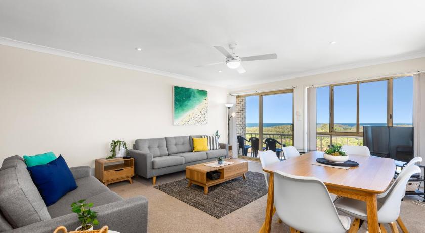 a living room filled with furniture and a large window, Hungerford Beach Apartment by Kingscliff Accommodation in Kingscliff