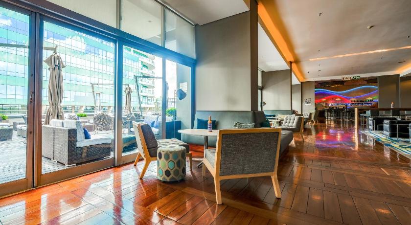 a living room filled with furniture and a large window, Radisson Blu Gautrain Hotel, Sandton Johannesburg in Johannesburg