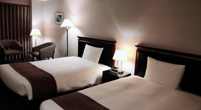 a hotel room with two beds and two lamps, Kurashiki Royal Art Hotel in Kurashiki
