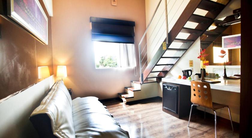 a living room filled with furniture and a window, Favor Hotel in Makassar