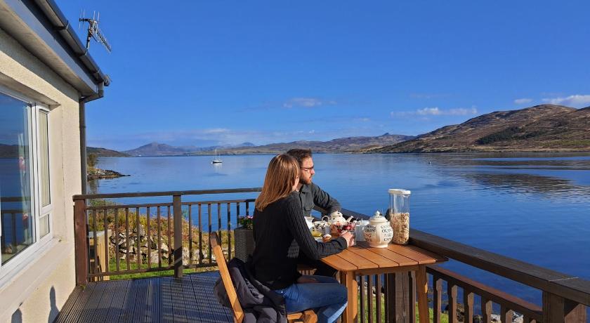 a woman sitting at a picnic table with a glass of water, Skye Picture House in Isle Of Skye
