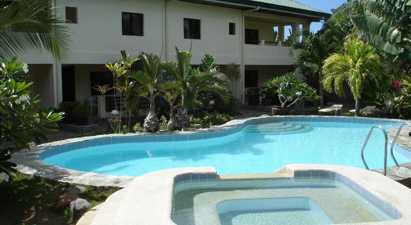 a large swimming pool in front of a house, Alona Swiss Resort in Bohol