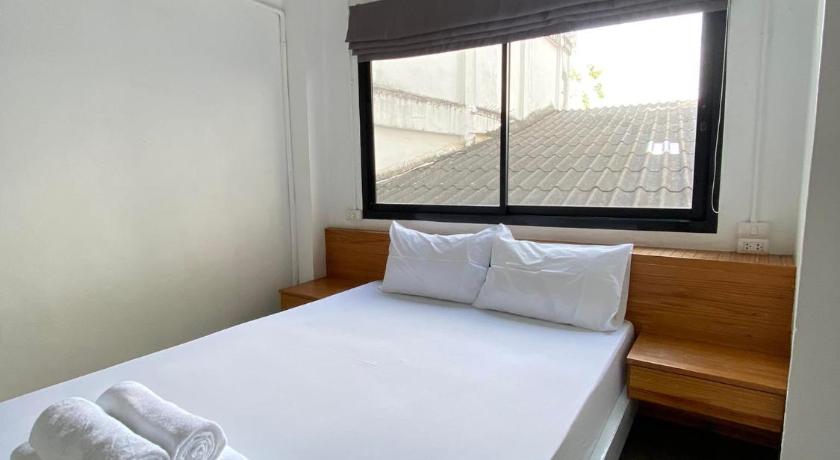 a hotel room with two beds and a window, THE PORT HOSTEL BY SUWATCHAI in Surat Thani
