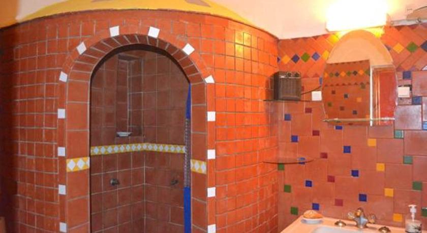 a bathroom with a stone wall and a brick wall, Maison d'hotes Cite Portugaise in El Jadida