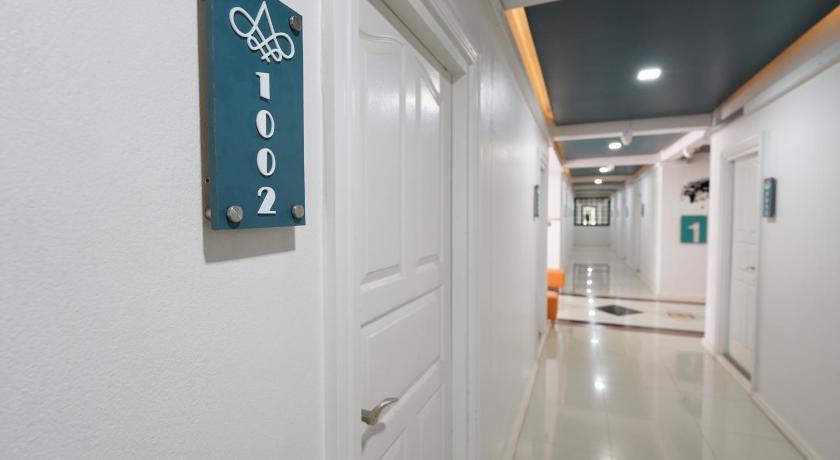 a hallway with a white wall and a blue door, RoomQuest Rojana Industrial Estate area in Prachinburi
