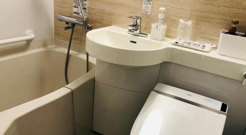 a bathroom with a sink, toilet and bathtub, Hotel Takasago in Kochi