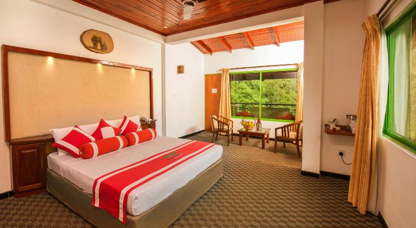 a bedroom with a large bed and a large window, Ramboda Falls Hotel in Nuwara Eliya