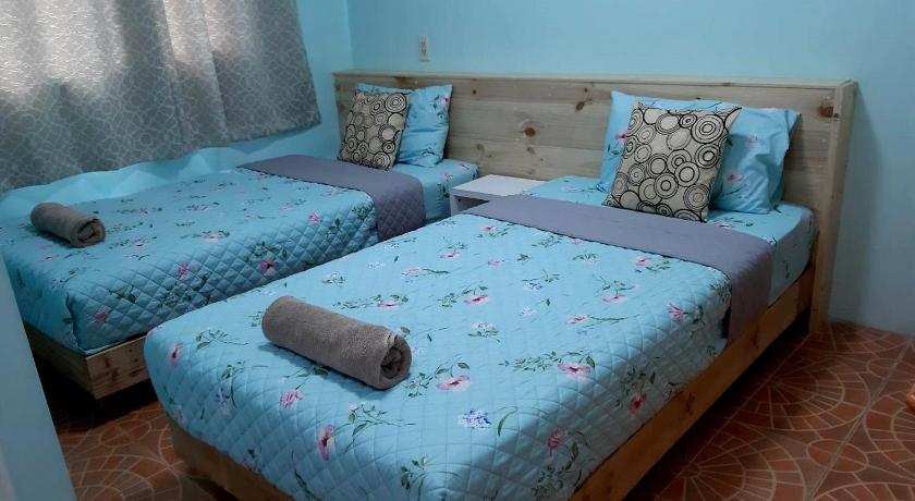 two beds in a room with blue walls, Sindy Room in Pattaya