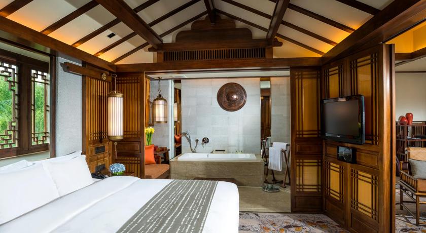a bedroom with a large bed and a large window, InterContinental Lijiang Ancient Town Resort in Lijiang