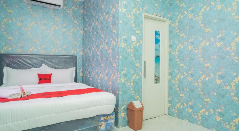 a bedroom with a blue and white bed and a blue wall, RedDoorz Plus near ITC Cempaka Mas 2 in Jakarta