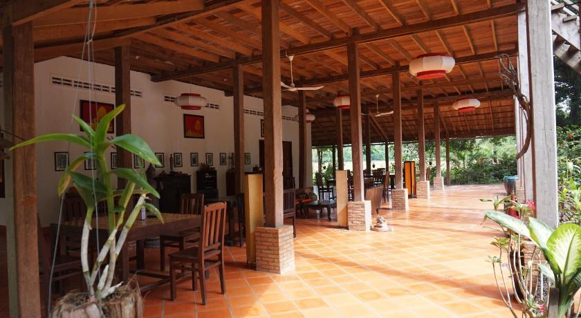 a patio area with chairs, tables, and umbrellas, Arun Mekong Guesthouse in Kratie