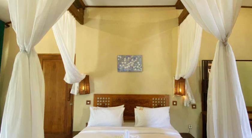 a bed with white sheets and a white bedspread, Sapulidi Resort Spa & Gallery in Bandung