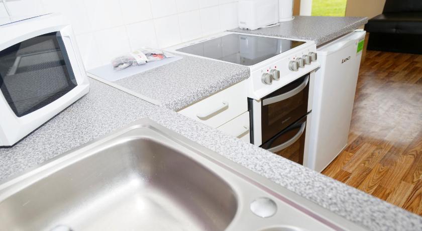 a kitchen with a microwave and a sink, Pontins-Southport Holiday Park in Sefton