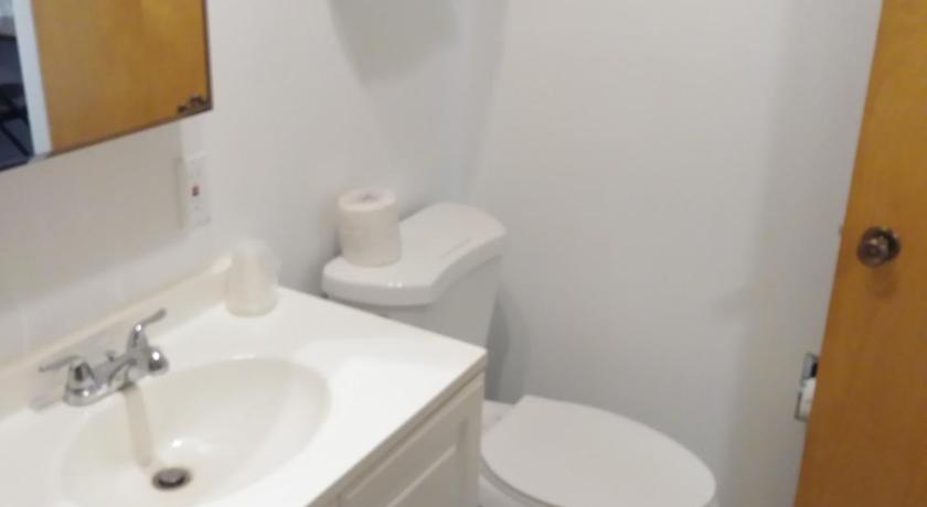 a white toilet sitting next to a sink in a bathroom, The Place Motel & Bar in Kenai (AK)