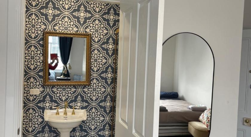 a bathroom with a toilet, sink, and mirror, The Royal Mail Hotel Braidwood in Braidwood