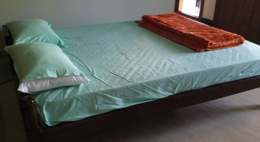 a bed that has a blanket on top of it, DWARAKA STAY INN-Rejoicing Family Home Coorg in Coorg