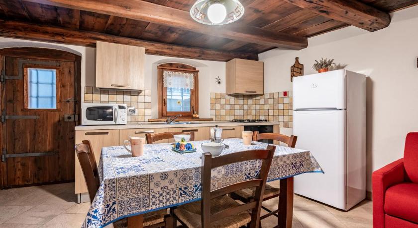 a kitchen with a table and chairs and a refrigerator, Locazione Turistica Les Cors-1 in Fenis