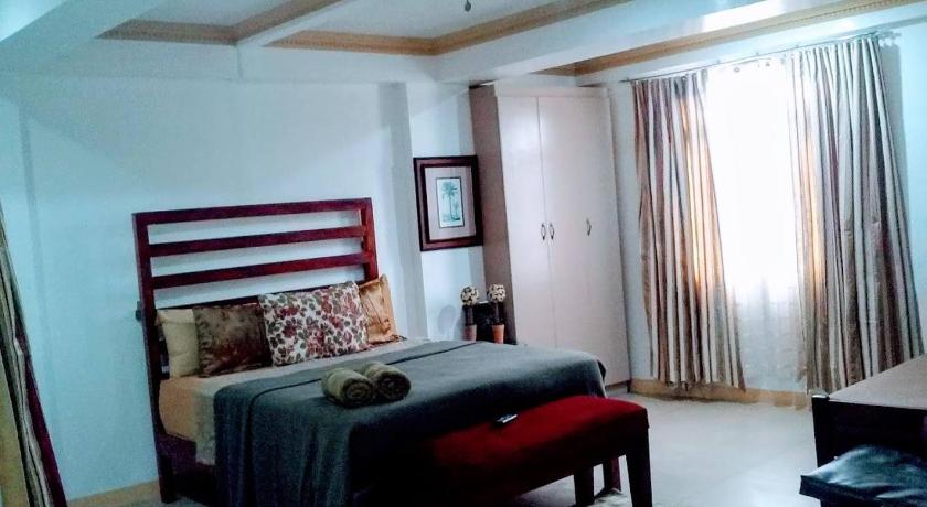 a living room filled with furniture and a window, The Saint Joseph Residential Suites in Lucena