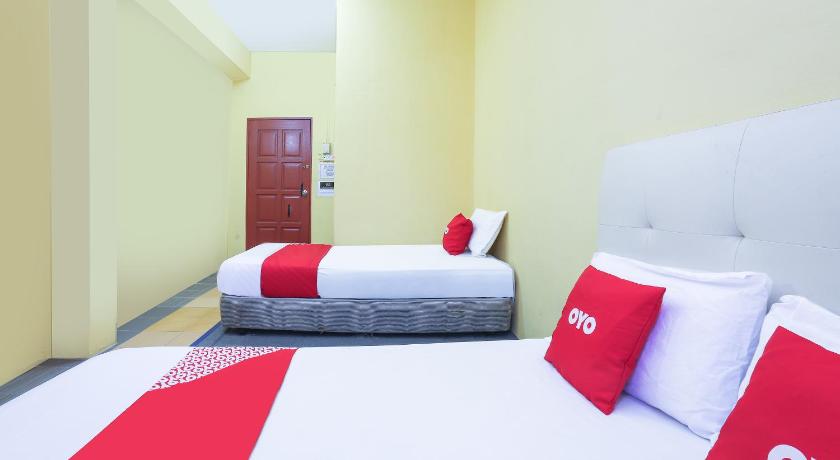 a hotel room with two beds and two lamps, OYO 90321 Hotel Bajet Sri Manal in Tanah Merah