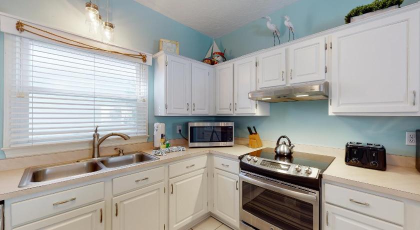 a kitchen with a stove top oven and a sink, Terra Cotta: Tropical Dreams in Destin (FL)