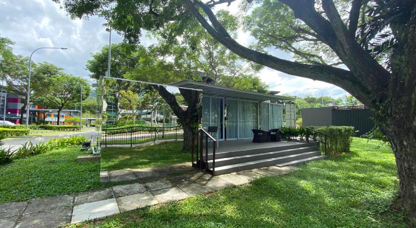 a park bench in the middle of a grassy area, Shipping Container Hotel @ one-north in Singapore