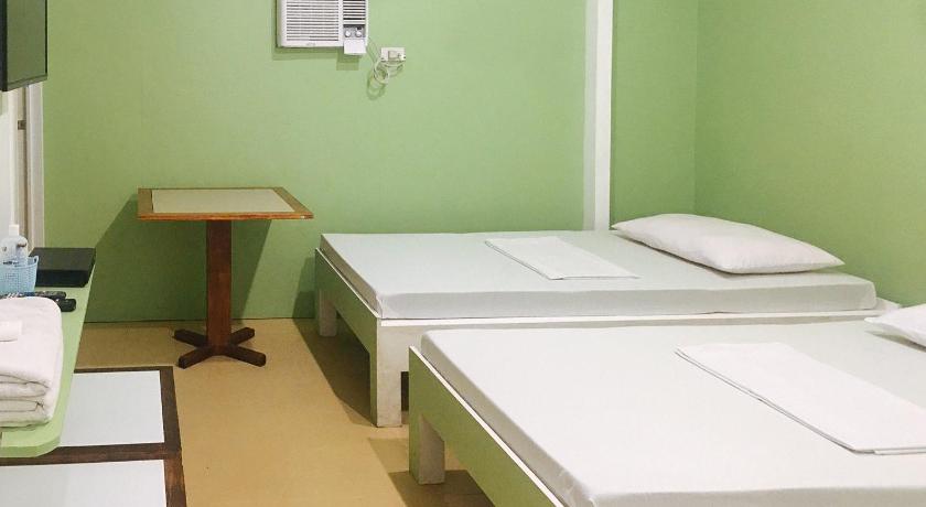 a bedroom with a bed and a desk, Mainstreet Pension House in Bacolod (Negros Occidental)