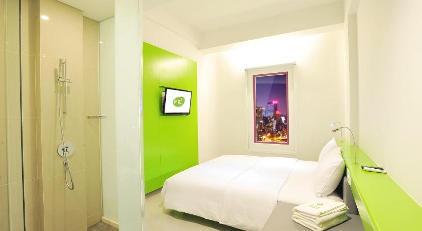 a bedroom with a white bed and a blue wall, POP! Hotel Diponegoro Surabaya in Surabaya
