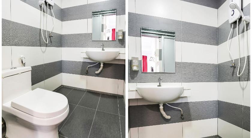 a bathroom with a toilet, sink and mirror, Super OYO 89495 Rich Hotel in Batu Pahat