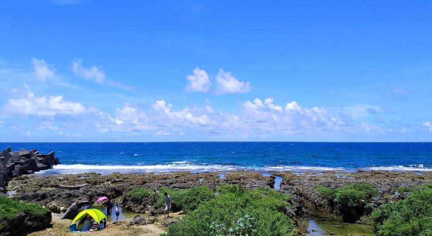 people on a beach near a body of water, 海邊小屋 in Kenting