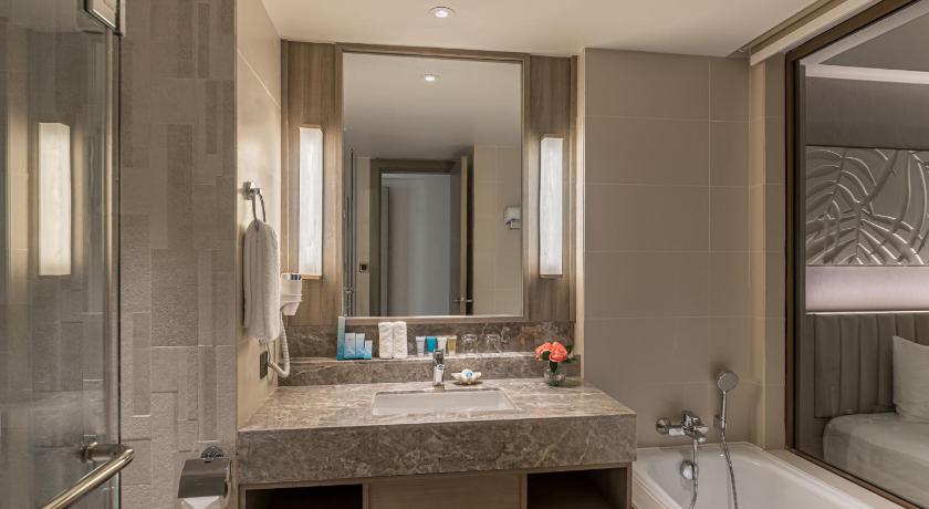 a bathroom with a sink, mirror, and bathtub, Henann Park Resort in Boracay Island