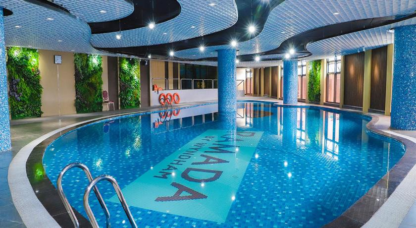 a swimming pool with a pool table and chairs, Ramada Hotel & Suites by Wyndham Halong Bay View in Hạ Long