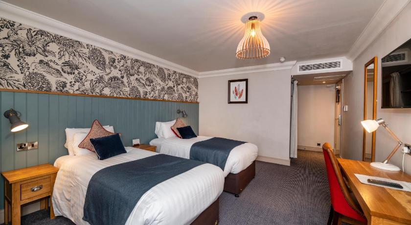 a hotel room with a bed and a desk, The Greswolde Arms Hotel by Good Night Inns in Birmingham