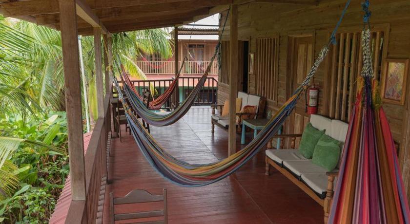 a room with a bed, a chair, and a table, Valerie Emanuel Apartments in Bocas del Toro