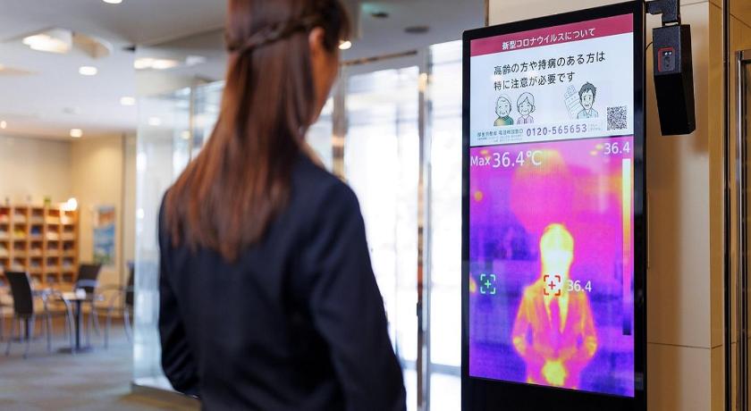 a woman standing in front of a tv in a room, Yokaichi Royal Hotel in Higashiomi