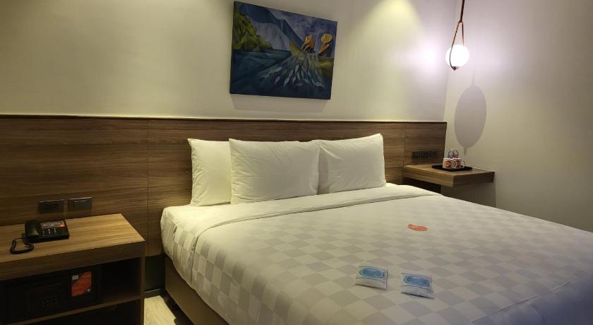 a hotel room with a bed and a lamp, Go Hotels Plus Tuguegarao in Tuguegarao City