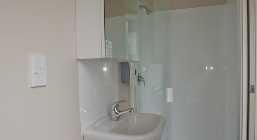 a bathroom with a shower, sink, and mirror, City Lodge Accommodation in Auckland