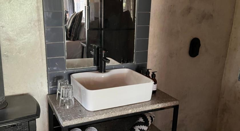 a bath room with a sink and a mirror, FOUR20 Bespoke Hotel in Johannesburg