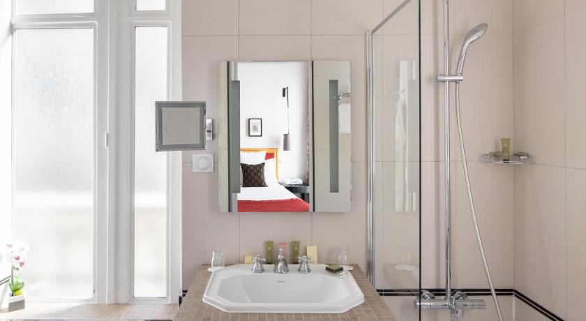 a bathroom with a sink, mirror and bath tub, Bradford Elysees - Astotel in Paris