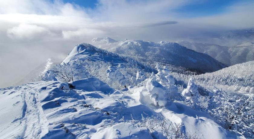 a mountain range with snow covered mountains, Pension Gooseberry in Furano