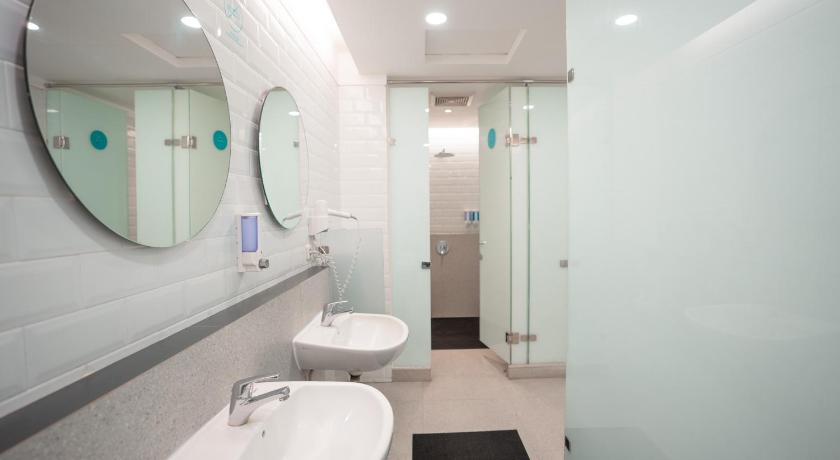 a bathroom with a sink, toilet and mirror, Bobobox Pods Paskal in Bandung